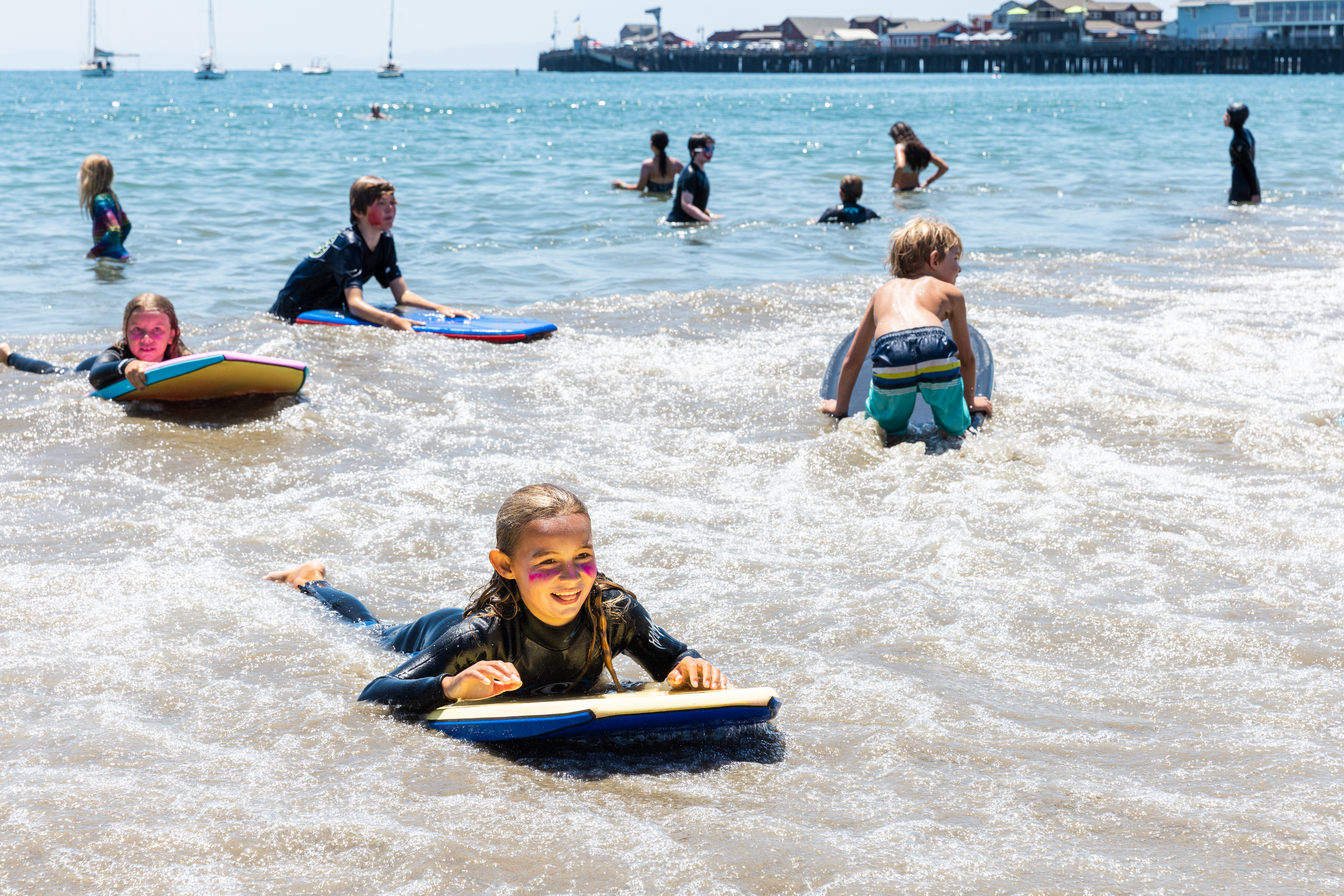 Campers boogie board along the shore