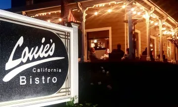 Louie's California Bistro sign with dining patio in background