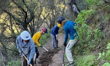 Volunteers work on repairing a damaged trail