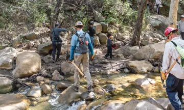 Volunteers hike with tools for trail restoration