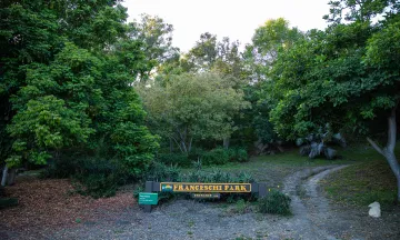 Picture of Franceschi Park entrance sign and walking path to the right