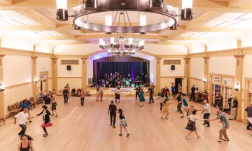 Dancers follow along during a swing dance lesson in the Carrillo Ballroom