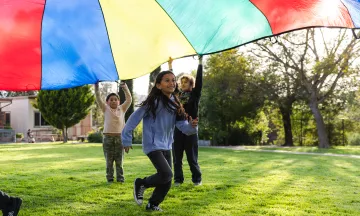 Students play with a giant parachute at the Recreation Afterschool Program