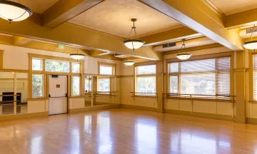 Carrillo Dance Studio 1 with wooden floors, mirrored ceilings, and ballet bars