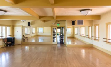 Carrillo Dance Studio 2 with wooden floors, mirrored ceilings, and ballet bars