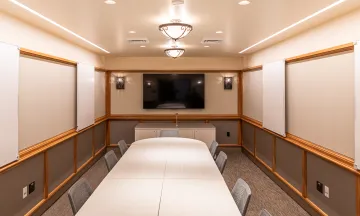 Cabrillo Pavilion conference room with a conference table and 10 chairs, featuring a television on the end wall and white boards on the side walls