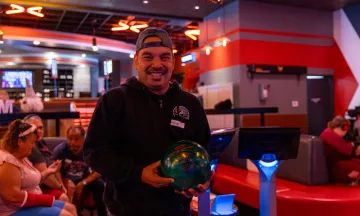 Adapted Recreation Program participant smiles for the camera before bowling