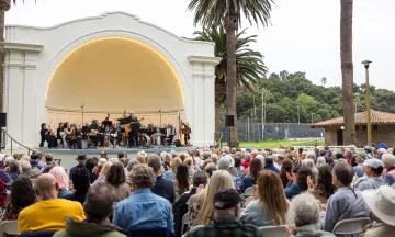 Folk Orchestra performing in front of a large crowd at the Plaza del Mar Band Shell