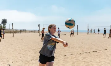 Beach volleyball camper bumps a volleyball at the East Beach courts