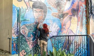 Teen artist in Arts Alliance restores a mural in Bohnett Park