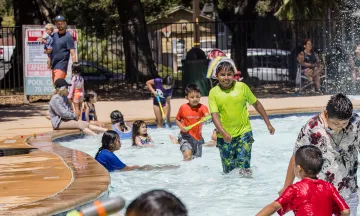 Youth play in the wading pool at Oak Park