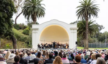 An audience watches an orchestra perform at the Plaza del Mar Band Shell