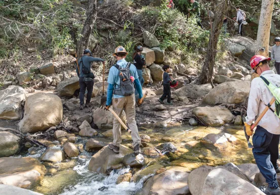Volunteers hike with tools for trail restoration