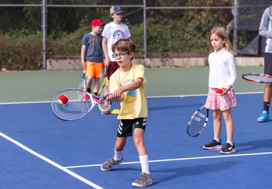 Tennis campers practice their forehand technique