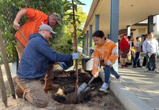 Adams Elementary students help staff plant a new tree on Arbor Day