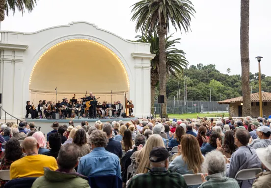 Folk Orchestra performing in front of a large crowd at the Plaza del Mar Band Shell