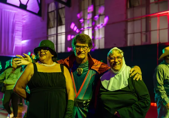 Three participants smiling at the camera in their Halloween costumes