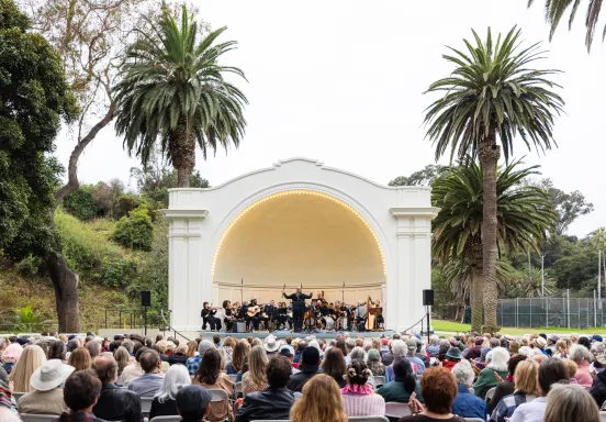 An audience watches an orchestra perform at the Plaza del Mar Band Shell