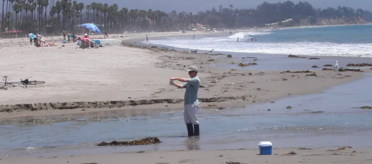 City staff collecting beach water quality sample