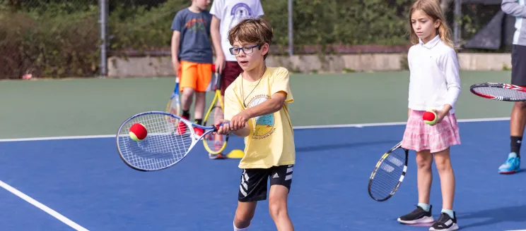 Tennis campers practice their forehand technique