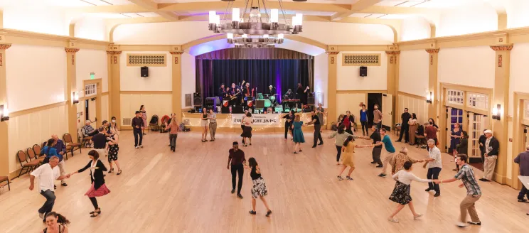 Dancers follow along during a swing dance lesson in the Carrillo Ballroom