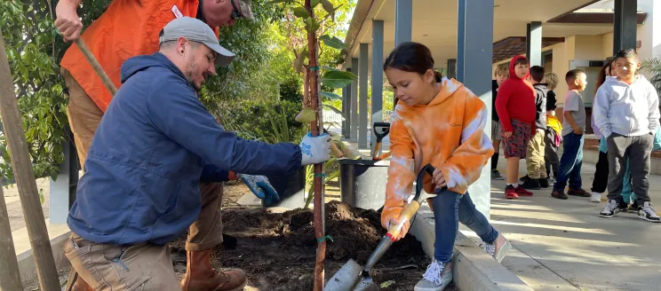 Adams Elementary students help staff plant a new tree on Arbor Day