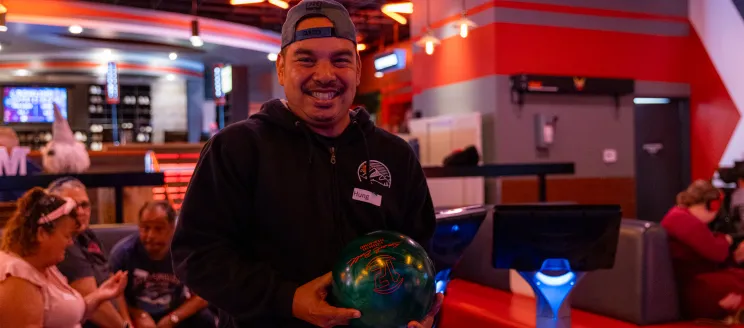 Adapted Recreation Program participant smiles for the camera before bowling