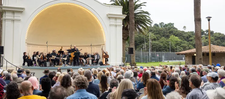 Folk Orchestra performing in front of a large crowd at the Plaza del Mar Band Shell