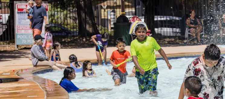 Youth play in the wading pool at Oak Park