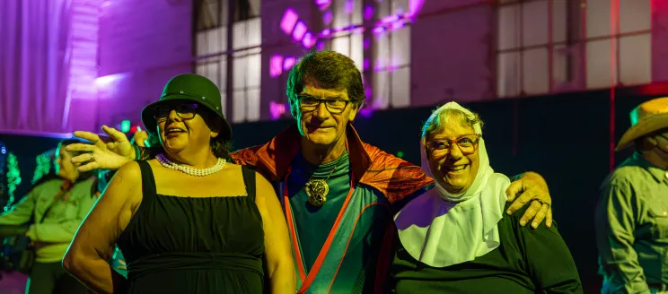 Three participants smiling at the camera in their Halloween costumes