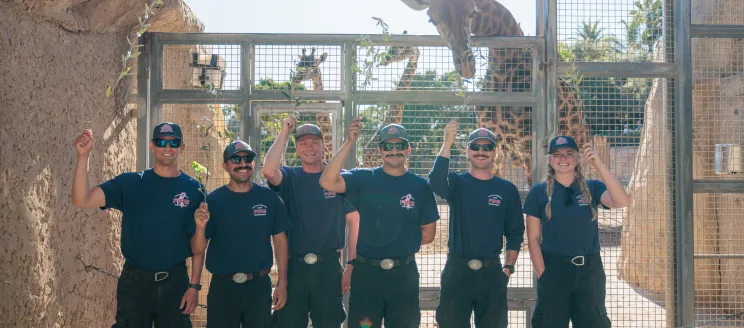 Wildfire resiliency staff pose in front of Giraffes at the SB Zoo