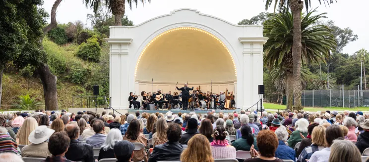 An audience watches an orchestra perform at the Plaza del Mar Band Shell