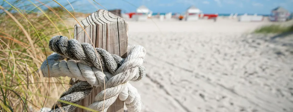 A beach with a rope tied to a post