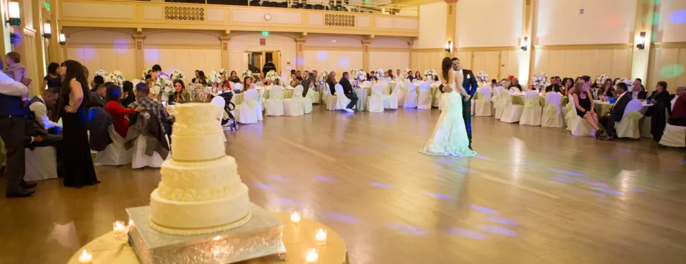 Wedding reception at Carrillo Ballroom with wedding cake in foreground