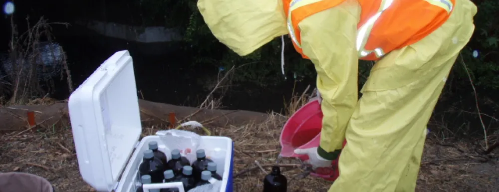 City staff collects creek water samples during a storm