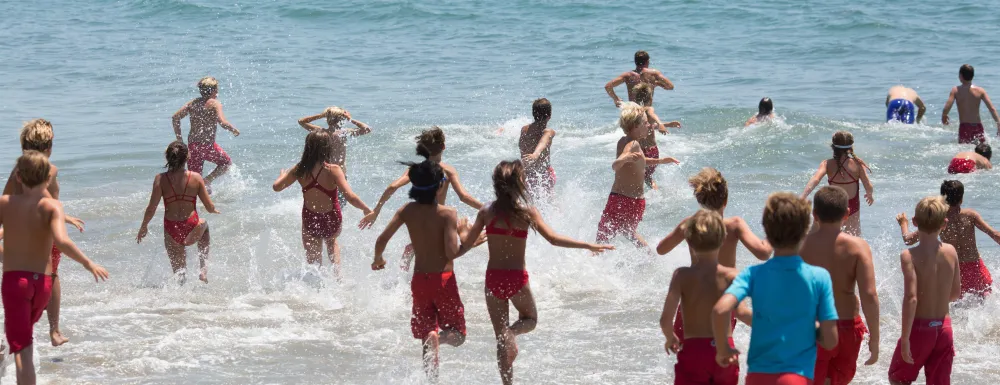 Jr. Guards running into the ocean