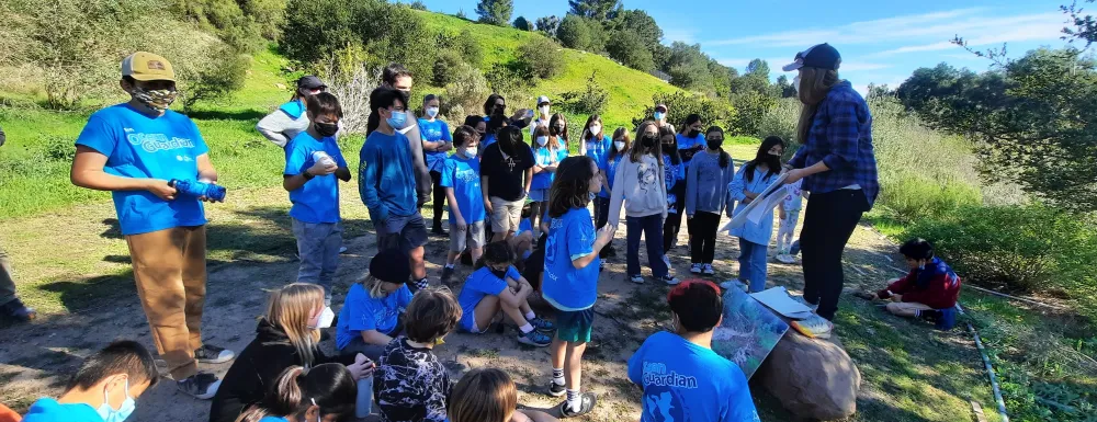 a group of children tour a creek restoration project