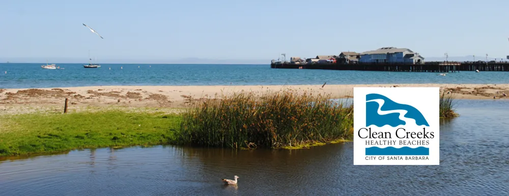 Mission Creek at East Beach with Stearns Wharf in the background, and the City of Santa Barbara Creeks Division logo