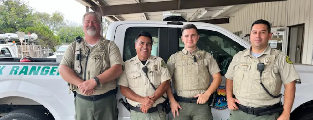 Four City of Santa Barbara Park Rangers stand in front of a white truck.