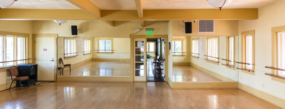 Carrillo Dance Studio 2 with wooden floors, mirrored ceilings, and ballet bars