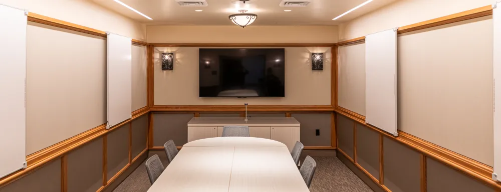 Cabrillo Pavilion conference room with a conference table and 10 chairs, featuring a television on the end wall and white boards on the side walls