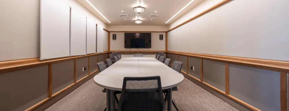 Cabrillo Pavilion conference room with a conference table and 10 chairs, featuring a television on the end wall and white boards on the side walls