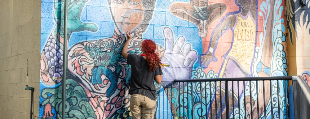 Teen artist in Arts Alliance restores a mural in Bohnett Park