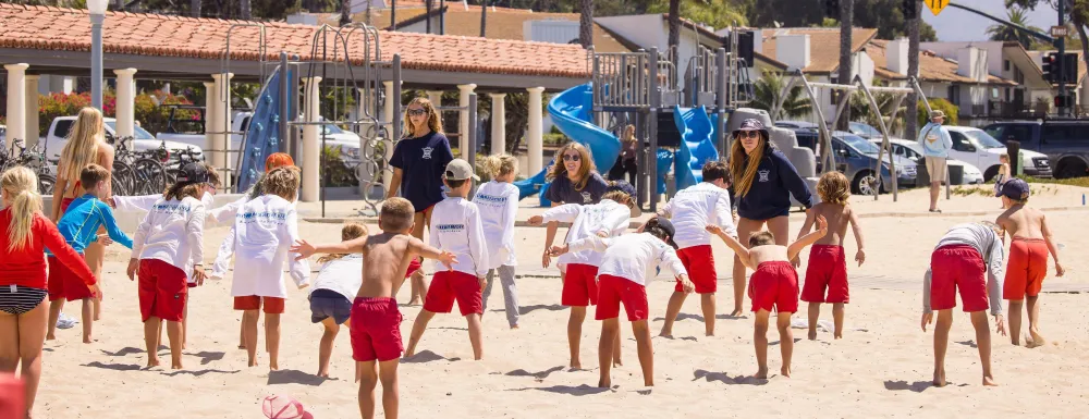 Junior Lifeguard campers do warm up drills in their uniforms