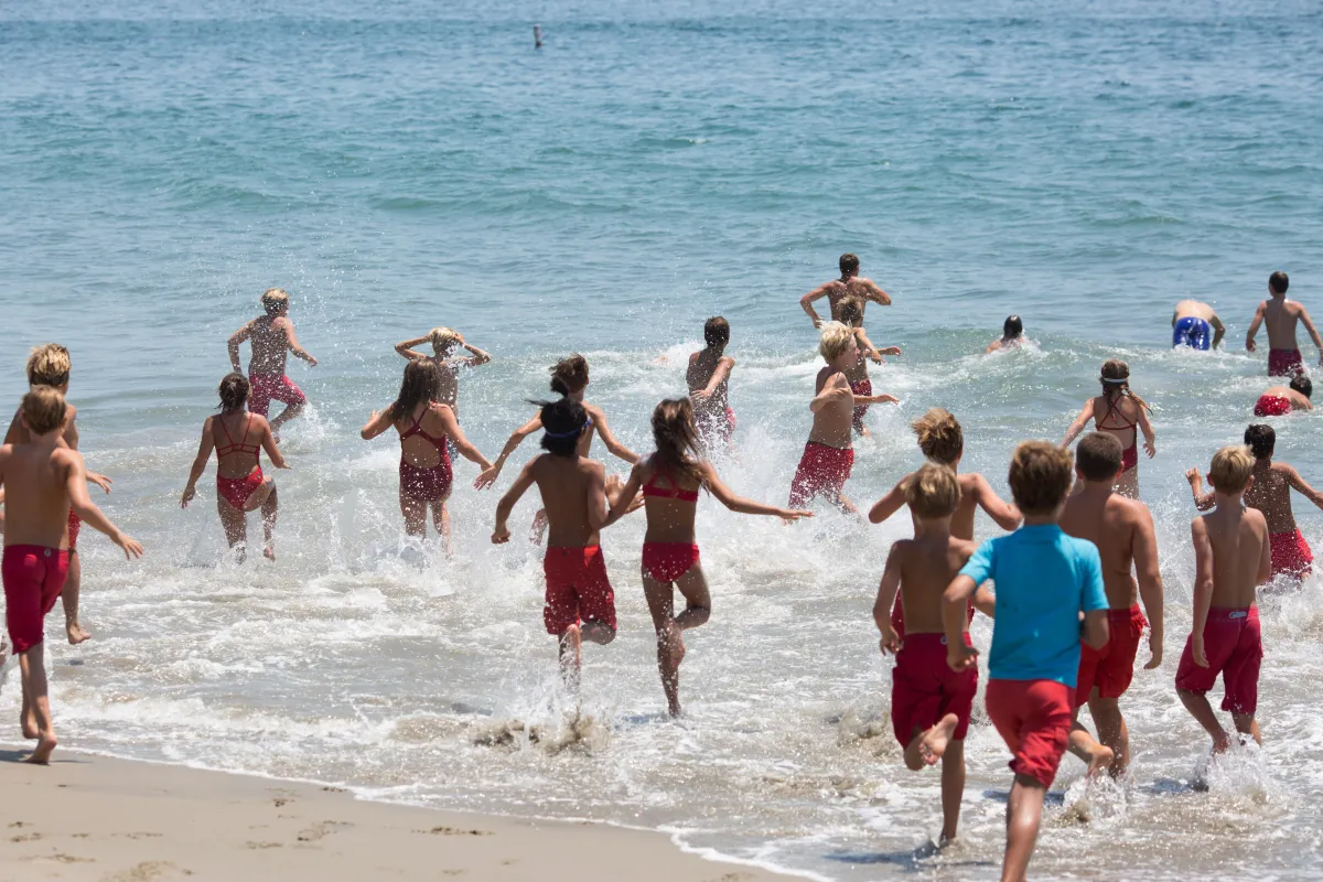 Jr. Guards running into the ocean