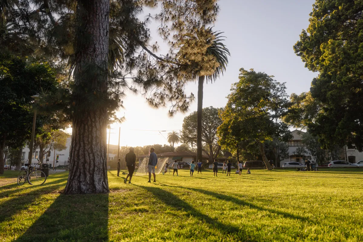 Community members run around at Alameda Park for an informal game of soccer