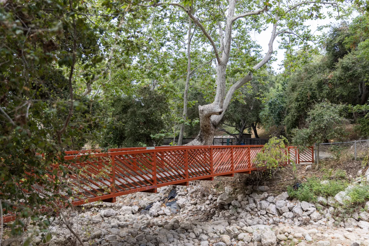 Red bridge connecting two areas of Oak Park across Mission Creek