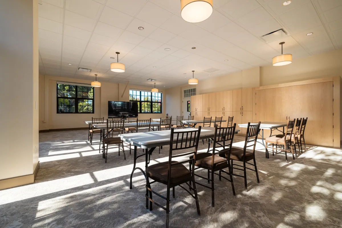 Louise Lowry Davis Center Activity Lounge with tables and chairs and a presentation TV