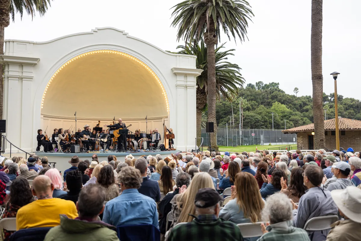 Folk Orchestra performing in front of a large crowd at the Plaza del Mar Band Shell