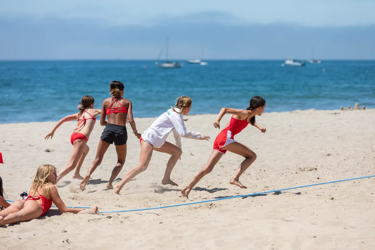 Junior Lifeguard campers running on East Beach